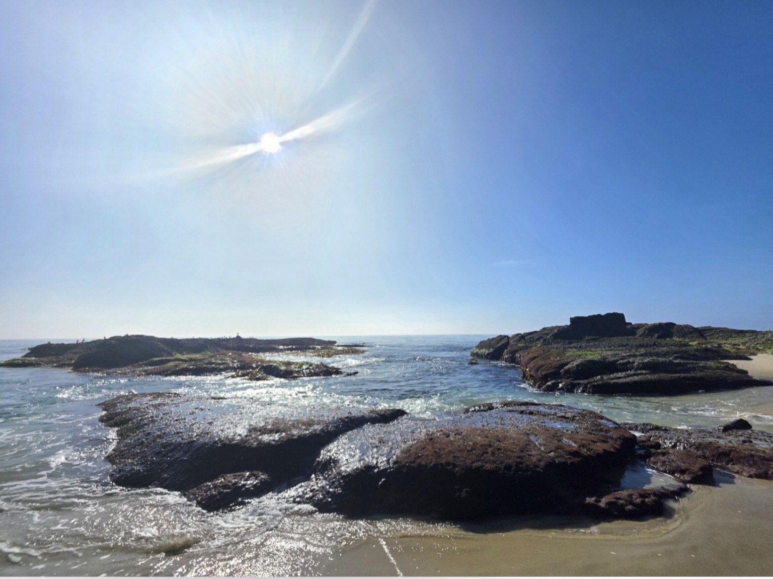 Sunlight over ocean water and coastal rocks